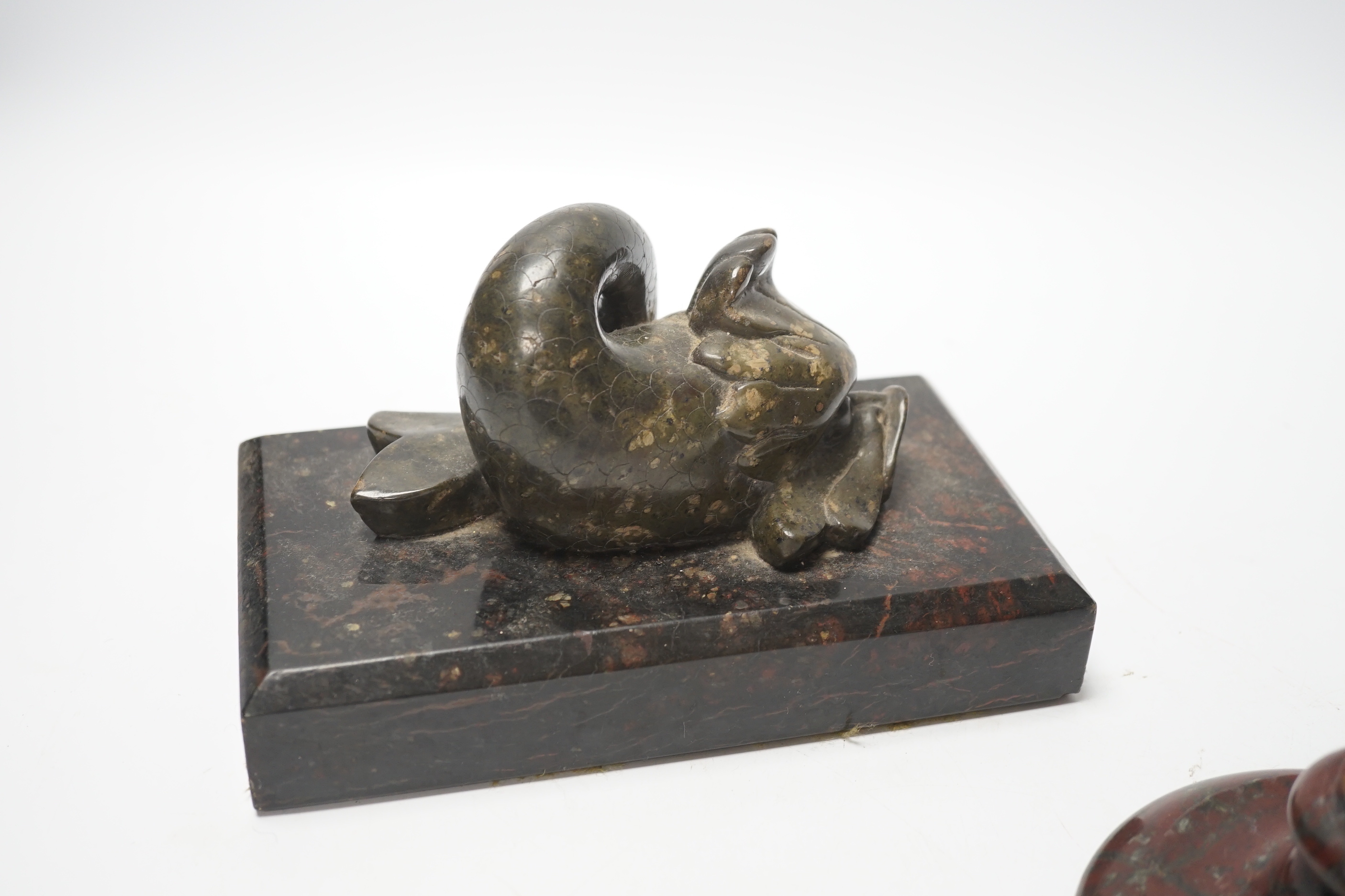 A 19th century serpentine candlestick and a carved dolphin paperweight, tallest 20cm high